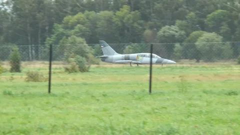 Fighter plane rides along the landing strip of old airfield. View from ground. Stock Footage 118677526