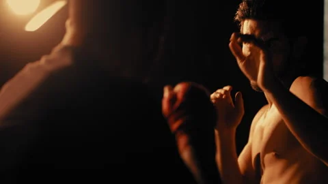 Fighter punching mans hand in a dark room Stock Footage 275083708