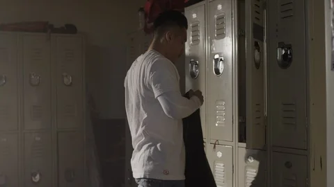 Fighter taking off sweater and hanging it on locker door in changing room 스톡 동영상 104534469