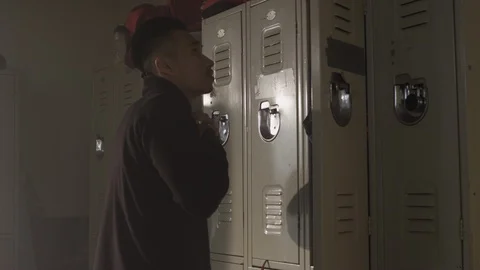Fighter taking off sweater in changing room in gym preparing to train Stock Footage 104532290