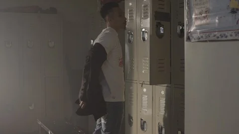 Fighter taking off sweater in changing room in gym preparing to train 스톡 동영상 104533977