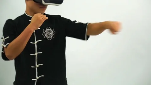 Fighter in VR headpiece makes impacts by hands in air Stock Footage 72684031