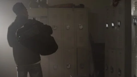 Fighter walks into gym changing room with big dufffle bag Stock Footage 104531533