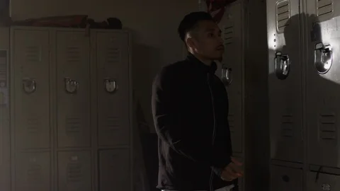 Fighter walks into gym locker room and opens locker getting ready to train Stock Footage 104535561