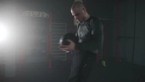 Fighter Warming up with a Medicine Ball Hitting it in his Stomach Stock Footage 174929065