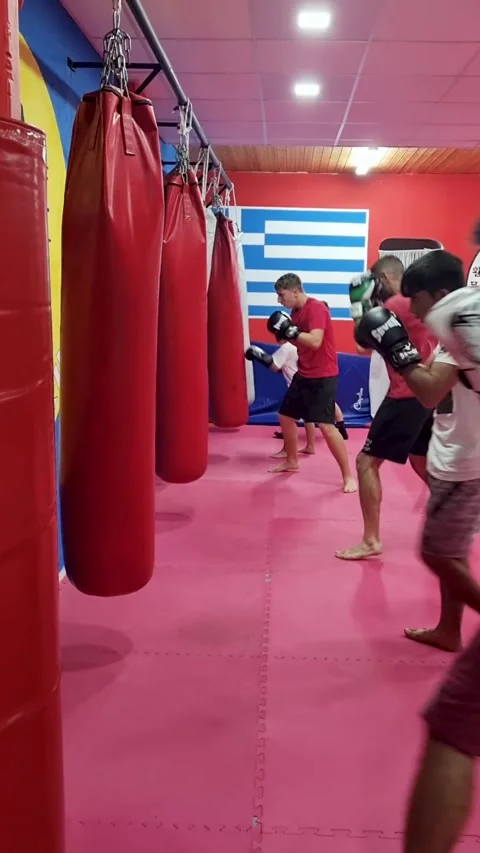 Fighters Training in a Boxing Class Hitting Red and Black Heavy Bags with Stock Footage 332584087