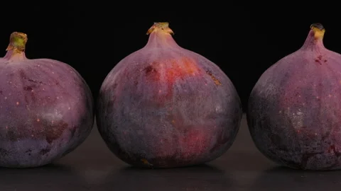 Figs against a dark background, camera smoothly gliding from left to right. Stock Footage 284048592