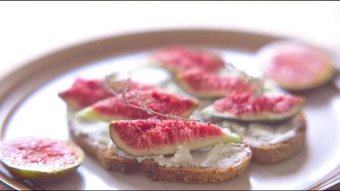 Figs on bread slice with cream cheese spread Stock Footage 76136448