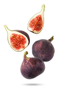 Figs falling whole and half on a white background. Isolated Stock Photos