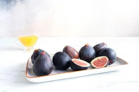 Figs lie on a white rectangular plate Photos