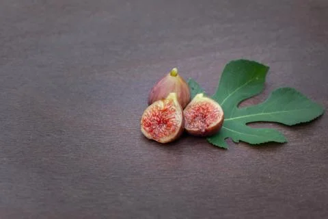 Figs on wooden table with fig leaf Stock Photos