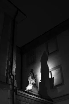 Figurative statue is lit by light during night. Stock Photos