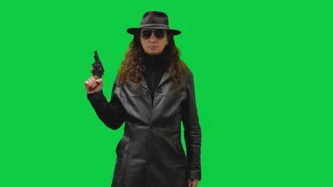 Figure in Black Leather Points Gun at Viewer - Green Screen Stock Footage 297409363
