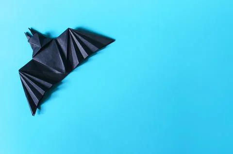 The figure of a dark bat on a colored background. Stock Photos