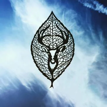 The figure of a deer on the background of a leaf from a tree. Animal figurine Stock Photos