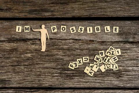 Figure diving impossible letter tiles sign into possible Stock Photos