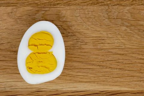 Figure eight cut egg with two yolks on wooden background, 8 march holiday Foto stock