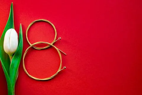 Figure eight of guitar strings on a red background. guitar neck Stock Photos