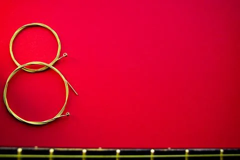 Figure eight of guitar strings on a red background. guitar neck Stock Photos