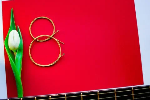 Figure eight of guitar strings on a red background. guitar neck Stock Photos