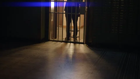 A figure with a flashlight opens a vault door in darkness, hinting at a Vídeos de archivo 278689931