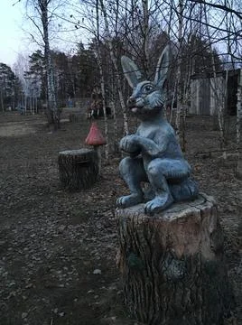 Figure of a hare on a stump in the forest Stock Photos