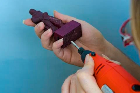 The figure of a knight from a tree. Grinding drill for jeweler. The girl drills Stock Photos