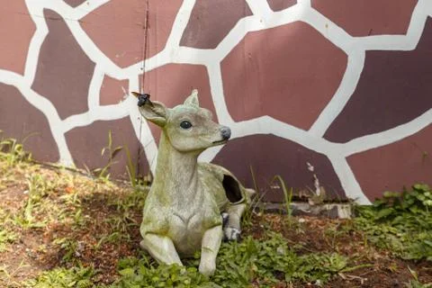 Figure of a lying deer with a beetle on the ear Stock Photos