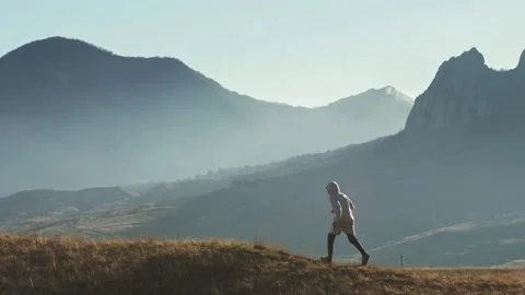 The figure of the runner moves from right to left against the backdrop of the Stock Footage 229948927