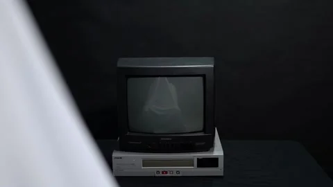 Figure in a sheet in front of a CRT TV Video stock 168474551