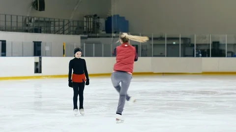 Figure skating coach showing how to whirl on ice Stock Footage 101628050