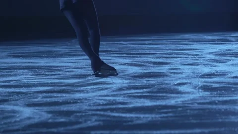 Figure skating lady is skating on ice rink, training alone at night in the rays Stock Footage 169333545