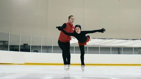 Figure skating trainer teaching trainee on ice Stock Footage 101630907
