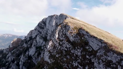 A figure standing on a cliff points towards the horizon 库存影片 168839807