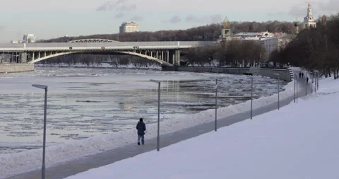 A figure strolls along the snow-covered embankment Stock Footage 263661812
