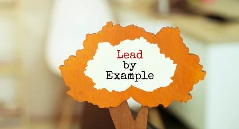 Figure of a tree with text Lead by example linside the foliage. Business conc Stock Photos