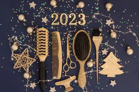 Figures 2023 scissors and comb with confetti on a dark background. Greeting card Stock Photos