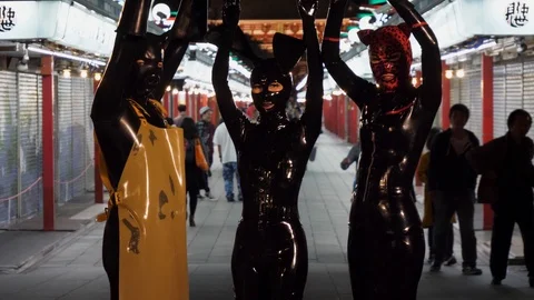 Figures dressed in Latex suits pose in front of the camera. Stock Footage 97849368