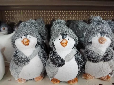 Figures on the New Year theme. Many penguin figures in warm gray hats Stock Photos
