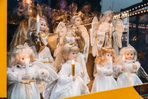 Figures of porcelain dolls of angels with candles in the window at Christmas Stock Photos