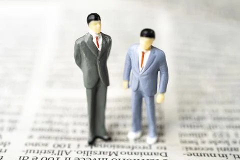 The figurine couple of two men on a page of the newspaper Stock Photos