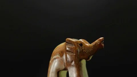 Figurine of an elephant on a black background Stock Footage 129697618