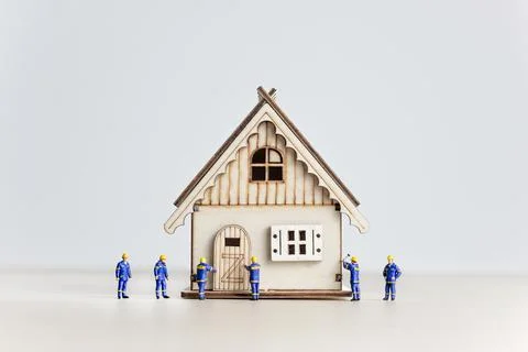 Figurines of builders working on the house. Developing concept Stock Photos
