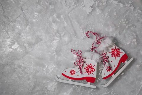 Figurines of ice skates with a red pattern on frosty ice, sparkling frost or Stock Photos