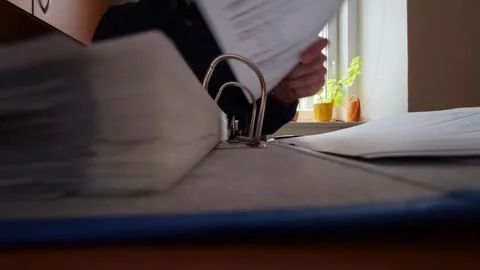 A file of documents that a man is leafing through at his desk. Office work Video stock 322182419
