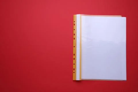 File folder with punched pockets and paper sheets on red background, top vi.. Stock Photos