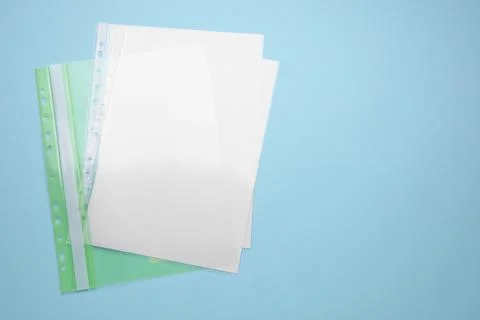 File folder with punched pockets and paper sheets on turquoise background, .. Stock Photos