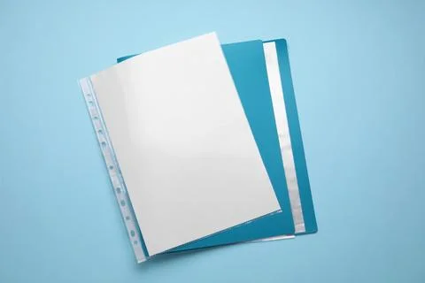 File folder with punched pockets and paper sheets on turquoise background, .. Stock Photos