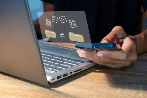 File transfer between mobile phone and laptop. Copy file and media or excha.. Stock Photos