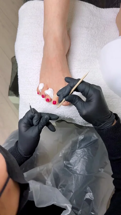 Filename pedicure master correcting red nail polish on toes Stock Footage 328178272